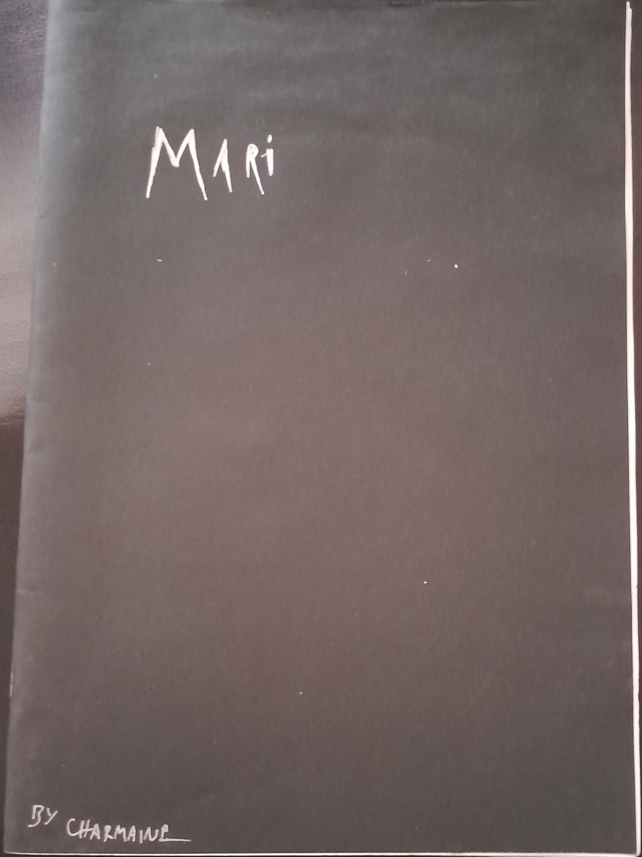 A plain black cover with the title, "Mari", written in a silver, scrawled font in the top left corner. The author's name, Charmaine, is written in a smaller font in the same colour in the bottom left corner.