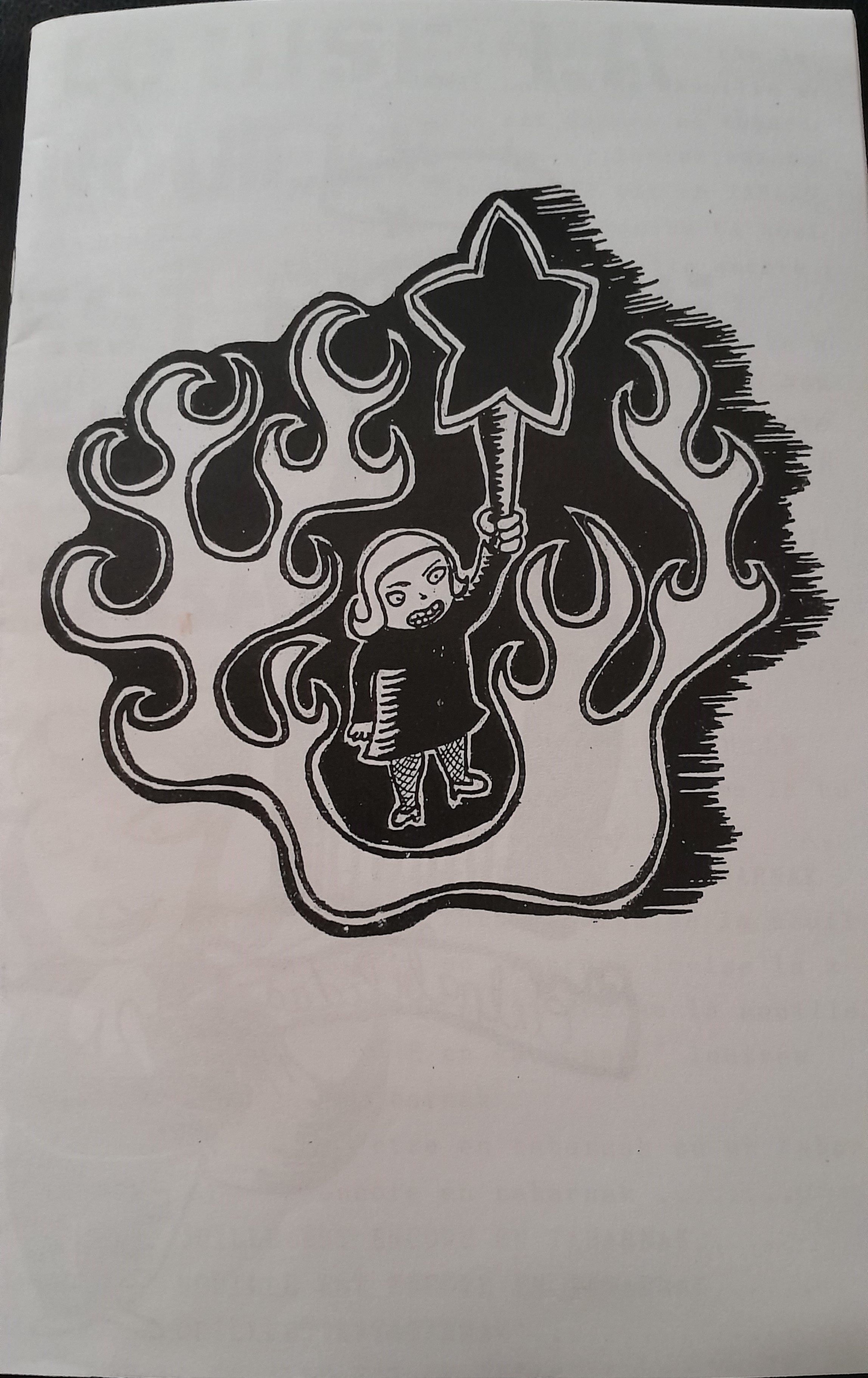 Black and white miscellaneous artzine depicting a young femme person standing among flames, holding a large wand with a star on the end.