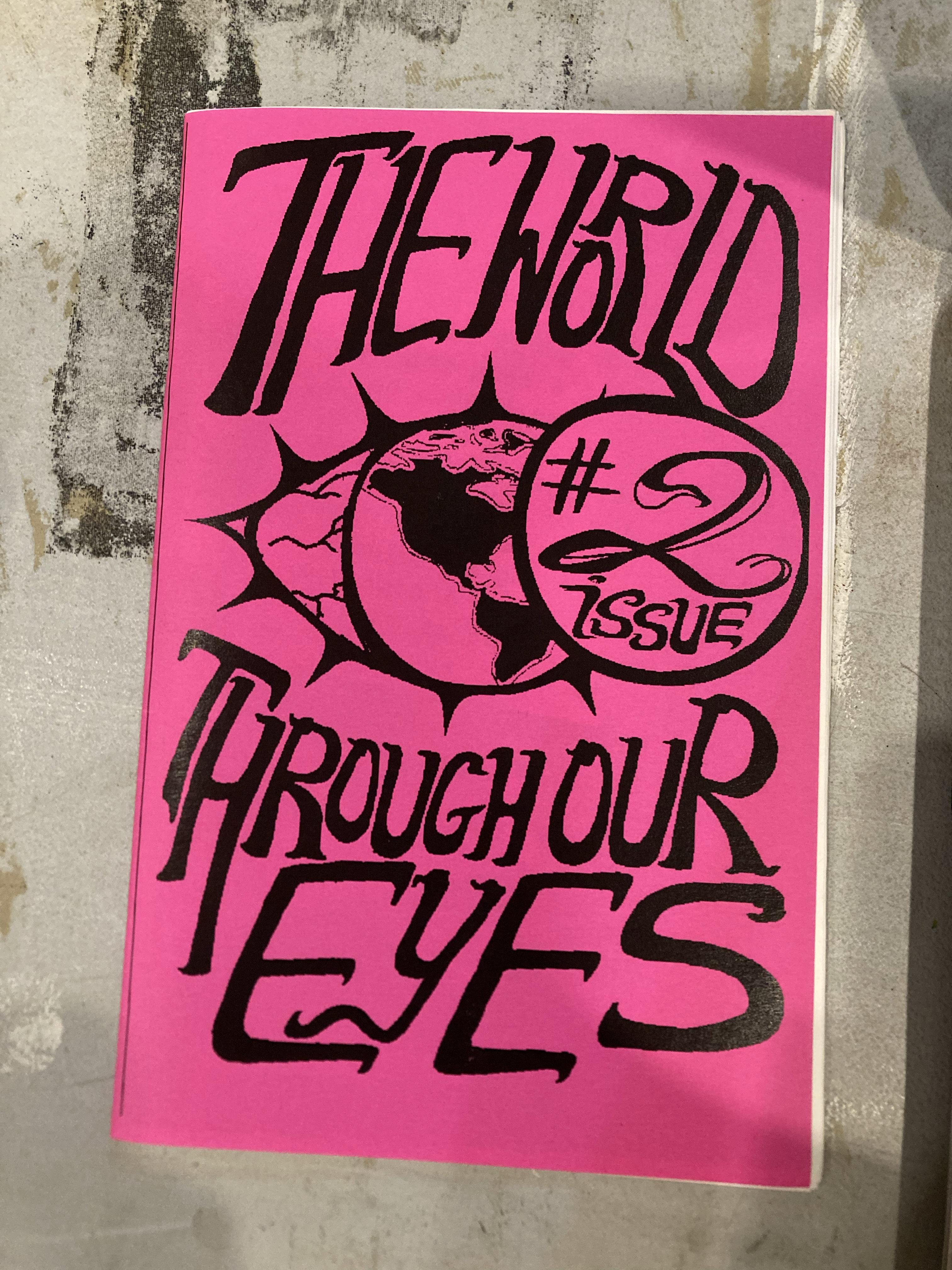 pink cover with a drawing of an eye with the Americas as the iris and large black text